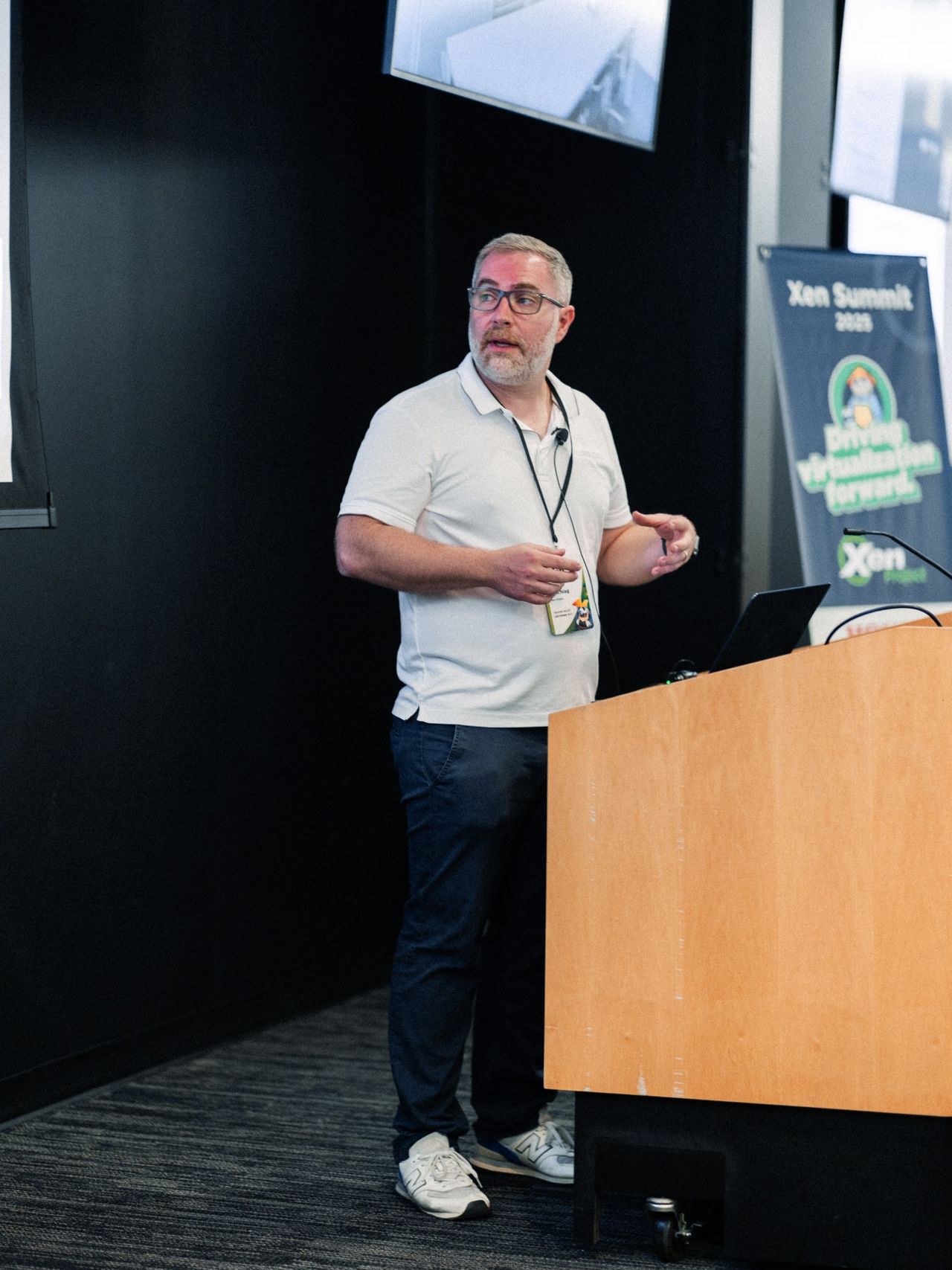 Cody speaking beside the podium at xen summit 2025